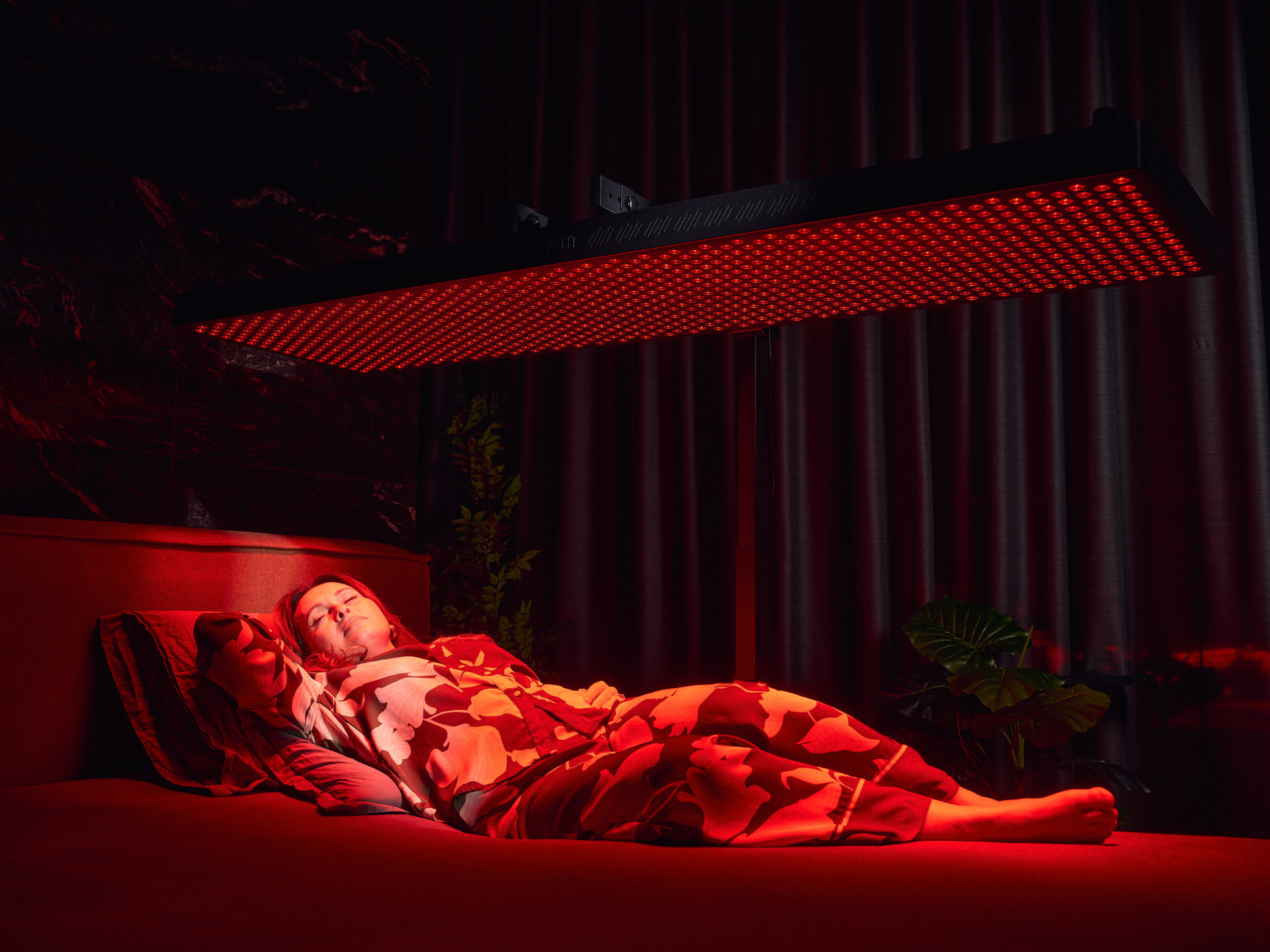 Full-body MITO LIGHT red and near-infrared panel positioned above a bed in a dedicated wellness room