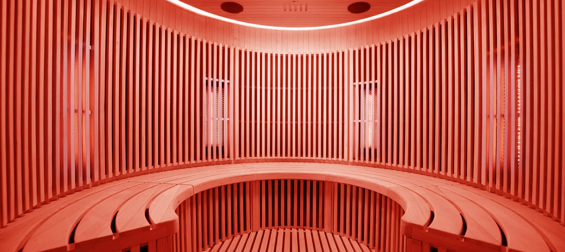 Holl's Moon 2 circular infrared sauna interior lit with warm red chromotherapy light